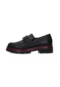 Scarpa in pelle nera con finitura texture, caratterizzata da un accento bordeaux sulla suola e un dettaglio a fibbia sulla tomaia. Design con suola spessa.