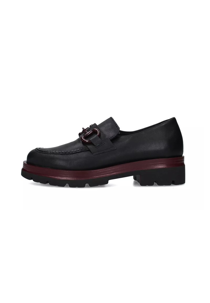 Scarpa in pelle nera con finitura texture, caratterizzata da un accento bordeaux sulla suola e un dettaglio a fibbia sulla tomaia. Design con suola spessa.