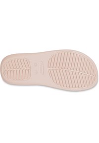 Lyserød Crocs-sål med en struktureret, skridsikker overflade. Har riller og en formet design. Størrelsen angivet som kvinders 7.