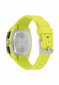 Sárga szilikon szíjas óra négyzet alakú rozsdamentes acél tokban, fényes részletekkel és gravírozott logóval a hátoldalon. Gumírozott textúrájú.