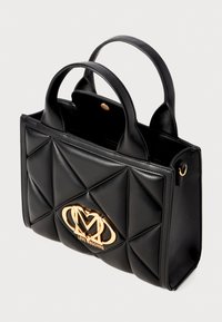 Black leather handbag with quilted pattern, gold hardware logo, dual handles, and snap closure. Stylish and structured design.
