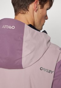 Paarse en roze kleurgeblokte hoodie-jack met een gladde textuur en een zilveren logo op de achterkant. Op maat gemaakte pasvorm, praktische ontwerpdetails.