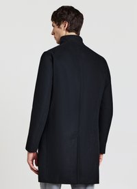 Schwarzer Wollmantel mit hohem Kragen, leicht tailliertem Schnitt und klaren Linien. Verfügt über eine glatte Textur und keine auffälligen Beschläge.