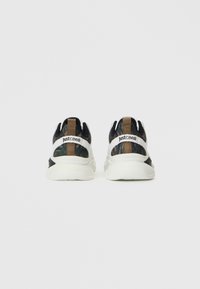 Ein Paar Sneaker mit Camouflage-Muster, weißer Sohle und braquem Zuglasche, von hinten betrachtet, mit der Marke "Just Cavalli" auf dem weißen Streifen.