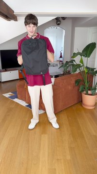 Black backpack made of durable material, featuring adjustable straps, a top handle, and a sleek, minimalist design.