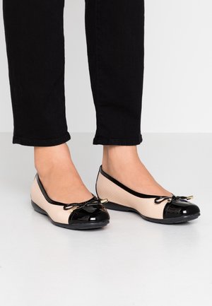 Baleriny z beżową teksturowaną siateczką na górze i czarnym lakierowanym noskiem. Detal w postaci kokardy ze sznurków oraz mały złoty akcent z boku.