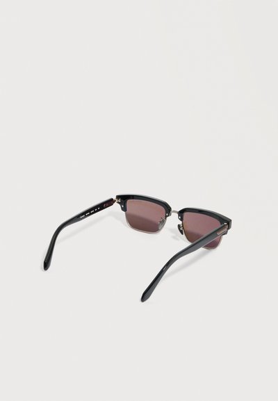 Sončna očala s črnim okvirjem, temnimi pravokotnimi stekli in srebrnimi poudarki, odprta na belem ozadju.