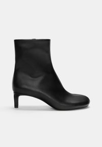 Bottine noire en cuir avec une forme épurée, un petit talon pointu, une texture lisse et un design minimaliste. Fermeture éclair sur le côté, couleur unie.