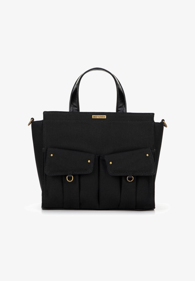 Bolso de lona negro con dos bolsillos frontales, acentos en oro y asas cortas de cuero. Presenta una forma estructurada y un tejido texturizado.