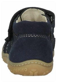 Marineblauwe suède kinder schoen met een klittenbandsluiting, witte stiksels, ronde neus en een flexibele rubberen zool met een gestructureerd patroon.