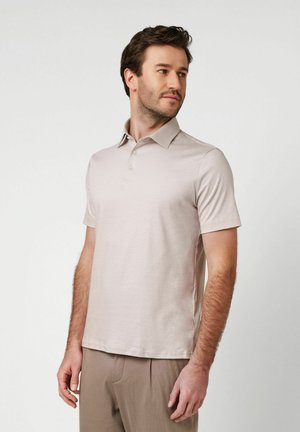 Hellbeiges Poloshirt mit klassischem Kragen, kurzen Ärmeln und einer Drei-Knopf-Leiste, gefertigt aus einem strukturierten, atmungsaktiven Stoff.