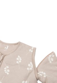 Haut en coton beige clair avec des imprimés de feuilles blanches, manches courtes et encolure ronde. Dispose d'une fermeture éclair sur le côté. Taille : 90 cm.