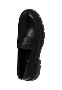 Mocassin en cuir noir avec semelle épaisse à crampons et bride sur le dessus, vu de dessus sur fond blanc.