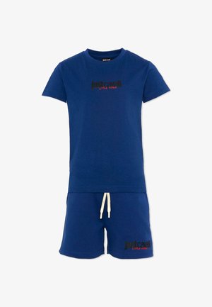 Ensemble composé d'un t-shirt bleu à manches courtes et d'un short, avec un cordon de serrage blanc, présentant le texte "Just Cavalli Little Rouge" en noir et rouge sur la poitrine et le short.