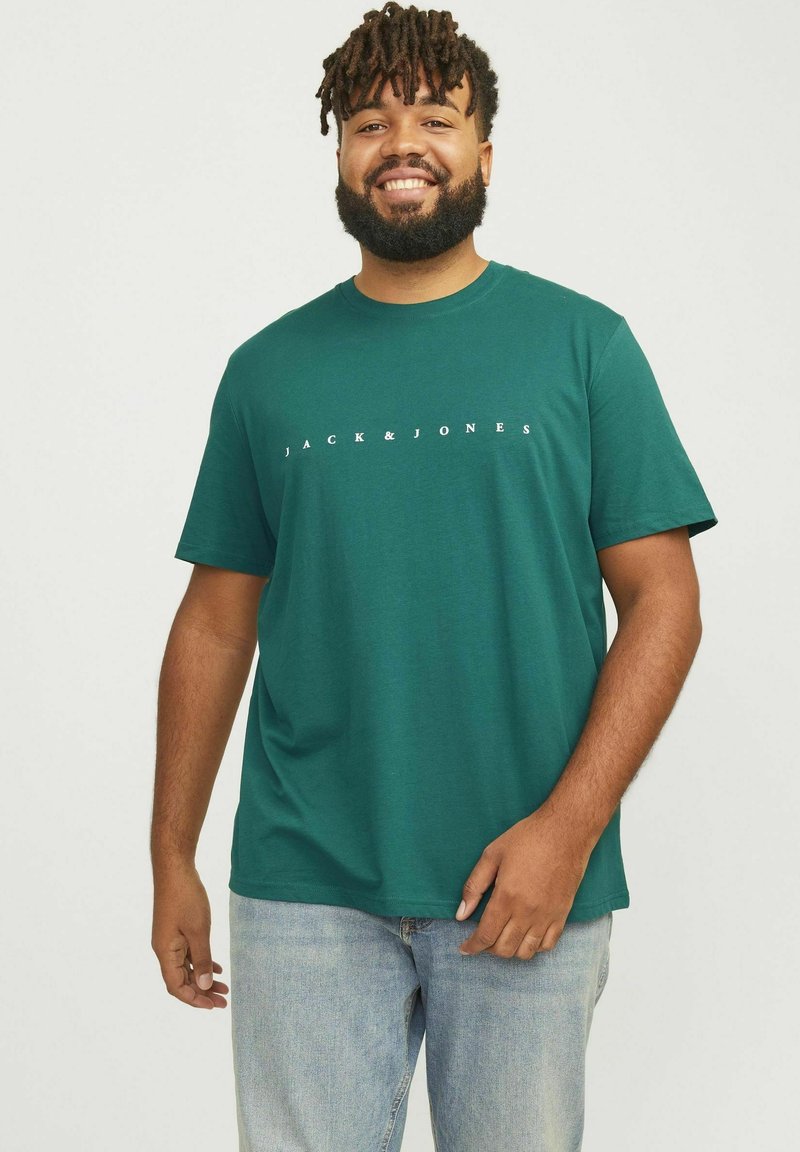 Teal katoenen t-shirt met korte mouwen, met een witte "JACK & JONES"-logo over de borst. Draag het met lichtblauwe jeans.