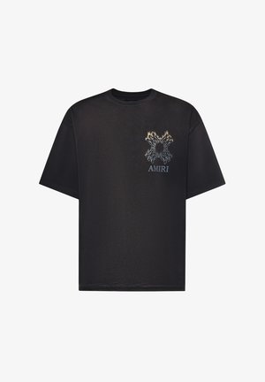 T-shirt noir à manches courtes avec un graphisme de toile d'araignée en flammes au-dessus du mot "AMIRI" sur le côté gauche de la poitrine.