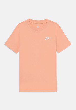 Svetlo breskvasasta bombažna majica s krojem in kratkimi rokavi. Ima majhen bel Nike logotip na prsih. Gladka tekstura.