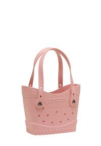 Roze rubberen totebag met een afgeronde vorm, textuur aan de onderkant en twee handvatten. Bevat ventilatiegaten en het "crocs" logo aan de zijkant.