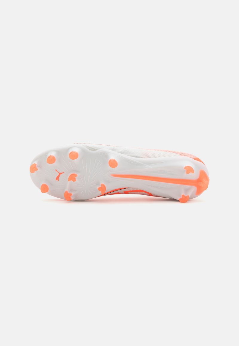 Chaussure de soccer avec une tige blanche, des accents orange et une semelle texturée dotée de crampons circulaires pour l'adhérence. Design léger et flexible.