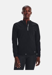 Čierny športový blejzer so zipsom, kapucňou a elastickými manžetami. Obsahuje biele logo "Under Armour" na prednej strane. Hladká, ľahká tkanina.