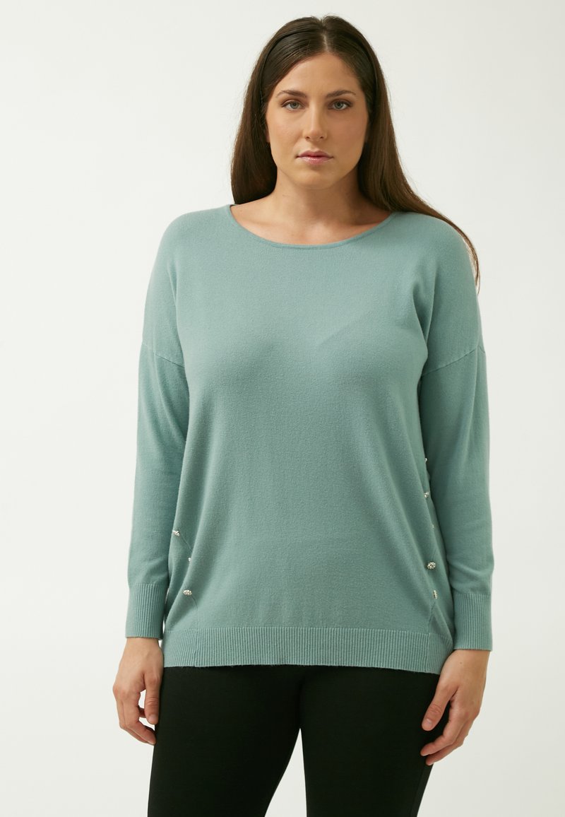 Lys teal sweater lavet af blødt stof, med scoop-udskæring og sidepynt af små dekorationer. Lange ærmer.
