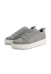 Baskets en daim gris avec une texture lisse, embout rond et semelle en caoutchouc blanc. Elles disposent d'un laçage traditionnel et de accents minimalistes.
