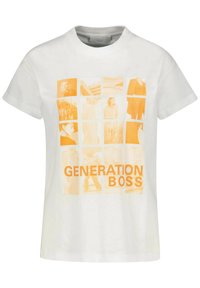 Valkoinen puuvillapaita, jossa on neliömäinen oranssi graafinen kuva, jossa on erilaisia kuvia ja teksti "GENERATION BOSS" rohkealla kirjasintyypillä alaosassa.