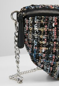 Borsa a tracolla in tweed nera e multicolore con manico in catena argentata, chiusura con zip e superficie tessuta testurizzata caratterizzata da fili di colori vari.