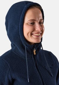 Navy blue fleece jacket with a hood, featuring a textured surface, adjustable cord with plastic tips, and a subtle embroidered logo.