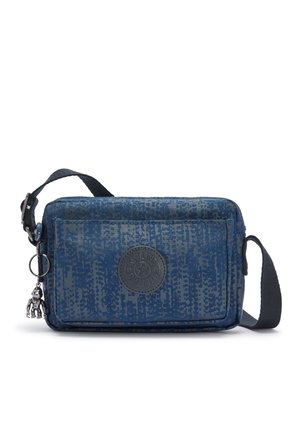 Kleine blauwe crossbodytas met patroonstof, voorvak met rits, ronde logopatch, zwarte verstelbare band en een zilveren sleutelhanger in de vorm van een aap.