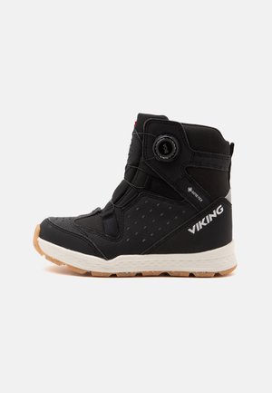 Bota vikinga negra de altura media con suela blanca, suela exterior de goma, cierre con dial BOA y etiqueta Gore-Tex en el lateral para impermeabilidad.