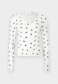 Λευκή μπλούζα με μακριά μανίκια και πλεκτή υφή, που διαθέτει κούφια στρίφωμα και λουλουδάτο σχέδιο σε ναυτικό μπλε και πράσινο.