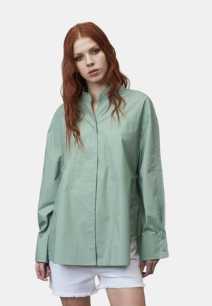 Camicia verde chiaro con colletto e maniche lunghe, realizzata in tessuto morbido. Presenta polsini con bottoni e una vestibilità rilassata e oversize.