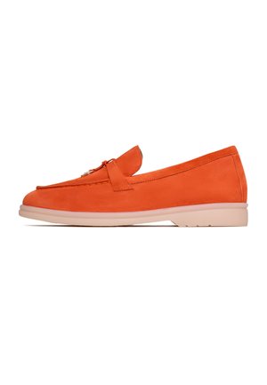 Mocassin en suede orange avec une semelle plate de couleur claire ; présente un nœud décoratif à l'avant et des lignes épurées et lisses dans le design.