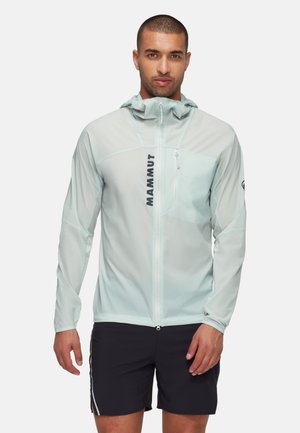 Giacca leggera verde menta a maniche lunghe con cappuccio regolabile, tasca con zip sul petto e logo nero "MAMMUT" sul davanti.