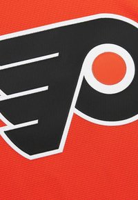 Logo dei Philadelphia Flyers con una "P" stilizzata nera e un cerchio arancione, cucito su uno sfondo in tessuto testurizzato arancione.