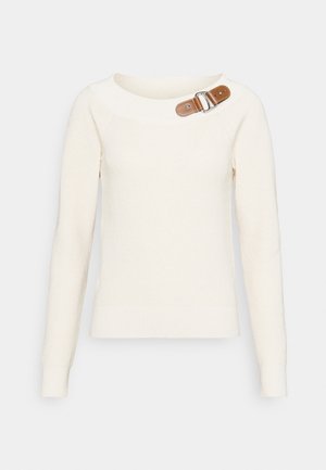 Jersey de punto de manga larga color crema con cuello redondo y detalle decorativo de hebilla de cuero marrón en el hombro izquierdo.