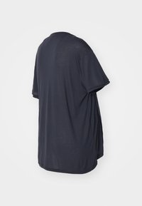 Camiseta de gran tamaño en color azul marino, hecha de tela suave, con mangas cortas, escote redondo y un corte relajado con un dobladillo curvado.