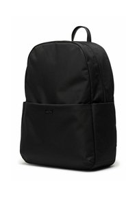 Sac à dos en tissu noir avec une texture lisse, de forme arrondie, poche avant et un logo subtil embossé à l'avant.