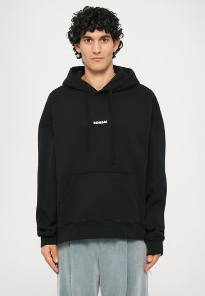 Zwarte hoodie met een kangoeroezak; heeft een witte "BONSAI" logo op de borst; gemaakt van zachte stof, comfortabele pasvorm, minimalistisch ontwerp.