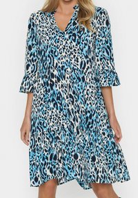 Blå och vit leopardmönstrad klänning med V-ringning och trekvarts ärmar med klockform; utsvängd, lagerdesign; lättviktigt tyg; knälång.