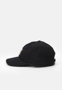 Gorra de béisbol negra con visera curvada, textura de tela y una etiqueta lateral con un logotipo. Diseño clásico sin adornos.