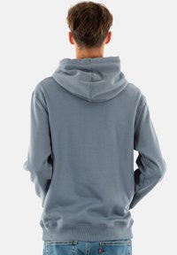 Felpa con cappuccio in misto cotone grigio chiaro, caratterizzata da una vestibilità comoda, polsini e orlo a coste. Texture morbida con un design essenziale.