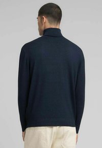 Maglione dolcevita blu navy realizzato in morbido tessuto a maglia, caratterizzato da collo alto e polsini a coste, progettato per una vestibilità comoda.