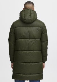 Olivengrøn pufjakke med hætte, udstyret med et quiltet design og vandret syninger. Lange ærmer og knælang pasform.