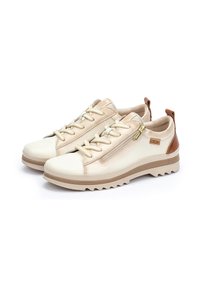 Chaussures beiges avec un dessus en cuir lisse et des accents texturés, dotées de pièces en métal doré, d'un système de laçage, et d'une semelle en caoutchouc striée.