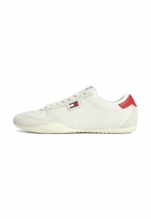 Low-profile white sneaker with lace-up design, small Tommy Jeans logo on side, and red accent on heel tab.