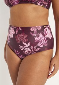Högmidjad bikiniunderdel i mörk burgundy med rosa blommönster. Slät tyg, elastisk midja och subtil logotypdetalj.