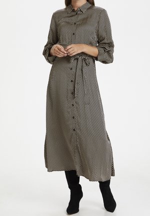 Zwart-witte polka dot midi-jurk met een knoopsluiting aan de voorkant, een strik in de taille en lange, omgeslagen mouwen. Gladde stof met een semi-doorzichtig textuur.