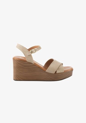 Sandalia cuña de ante beige con suela de plataforma de madera, correa en el tobillo y hebilla dorada, diseño de puntera abierta.